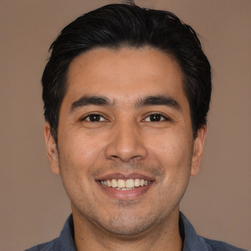 Joyful white young-adult male with short  black hair and brown eyes