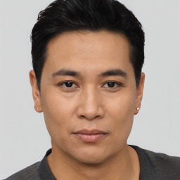 Joyful asian young-adult male with short  black hair and brown eyes