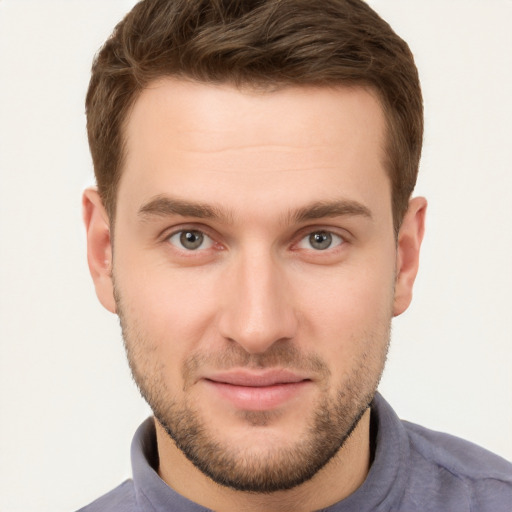 Joyful white young-adult male with short  brown hair and grey eyes