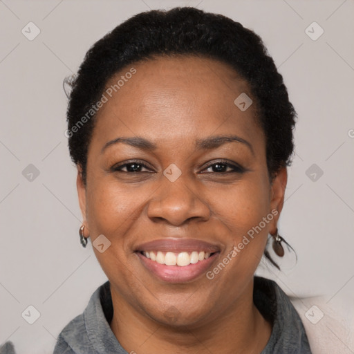 Joyful black adult female with short  black hair and brown eyes