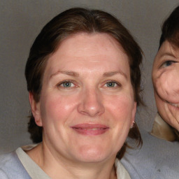 Joyful white adult female with medium  brown hair and blue eyes