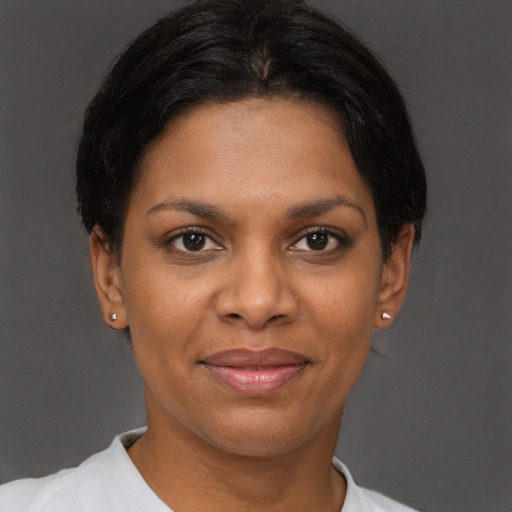 Joyful black adult female with short  brown hair and brown eyes