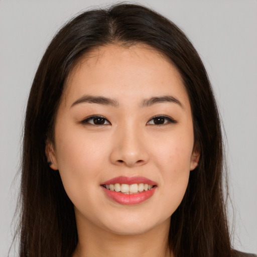 Joyful asian young-adult female with long  brown hair and brown eyes