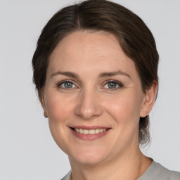 Joyful white adult female with medium  brown hair and grey eyes