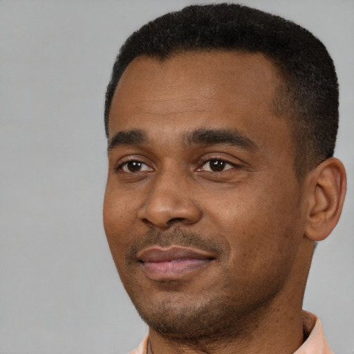 Joyful black young-adult male with short  black hair and brown eyes