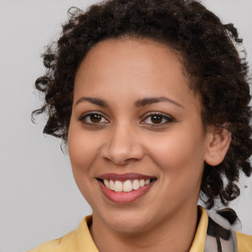 Joyful black young-adult female with medium  brown hair and brown eyes