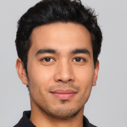 Joyful latino young-adult male with short  black hair and brown eyes