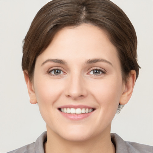 Joyful white young-adult female with short  brown hair and grey eyes