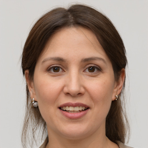 Joyful white young-adult female with medium  brown hair and brown eyes