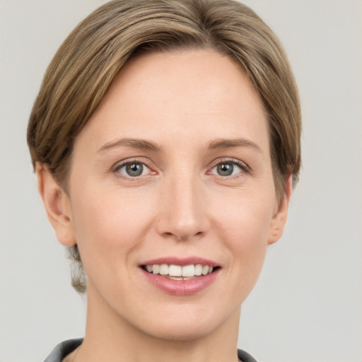 Joyful white young-adult female with short  brown hair and grey eyes