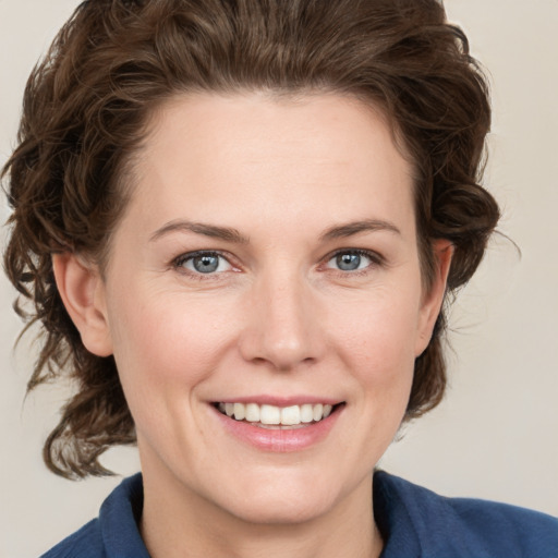 Joyful white young-adult female with medium  brown hair and blue eyes