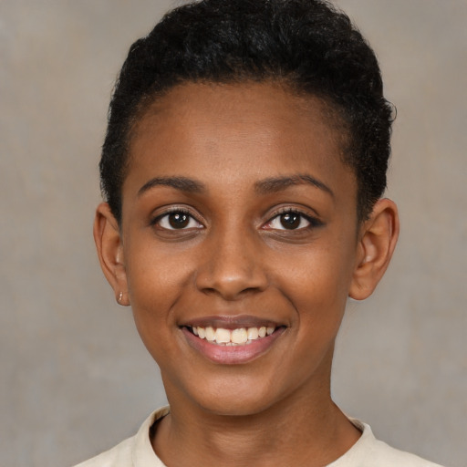 Joyful black young-adult female with short  brown hair and brown eyes