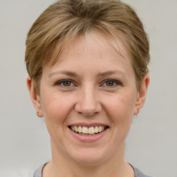 Joyful white young-adult female with short  brown hair and grey eyes