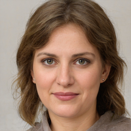 Joyful white young-adult female with medium  brown hair and grey eyes