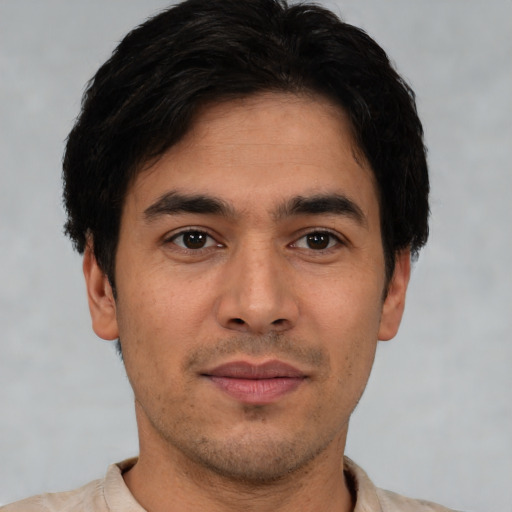 Joyful white young-adult male with short  black hair and brown eyes