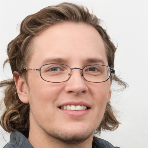 Joyful white adult male with medium  brown hair and blue eyes