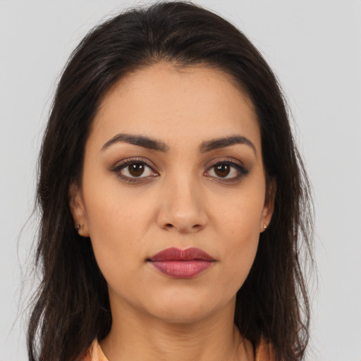 Joyful latino young-adult female with long  brown hair and brown eyes
