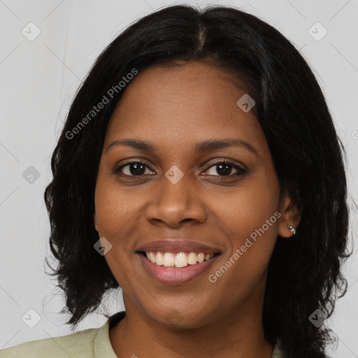 Joyful black young-adult female with long  brown hair and brown eyes