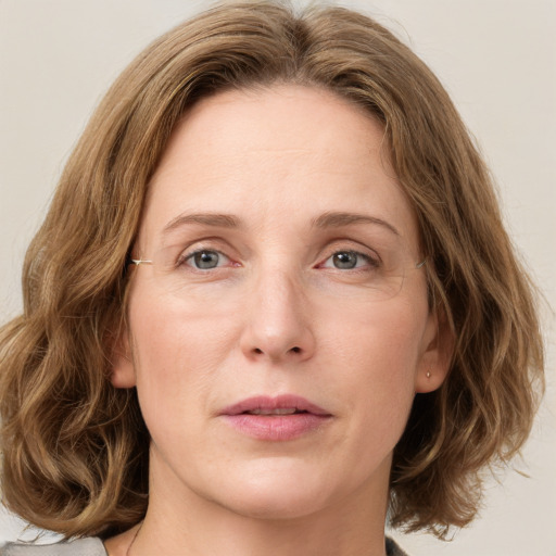 Joyful white young-adult female with medium  brown hair and green eyes