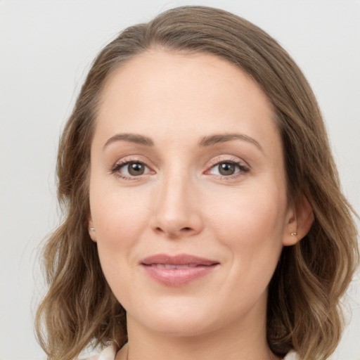 Joyful white young-adult female with medium  brown hair and green eyes