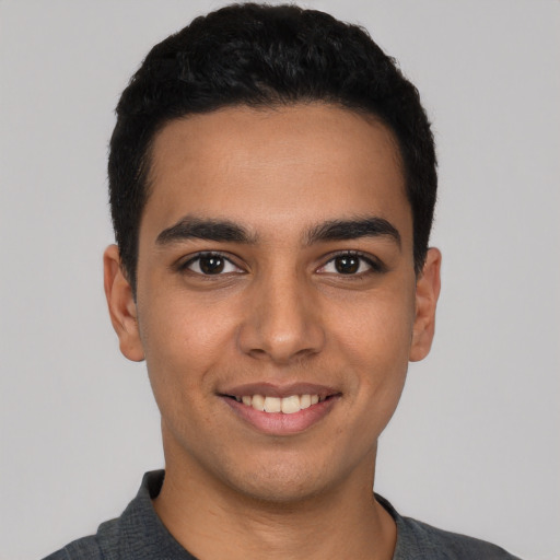 Joyful latino young-adult male with short  black hair and brown eyes