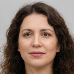 Joyful white adult female with long  brown hair and brown eyes