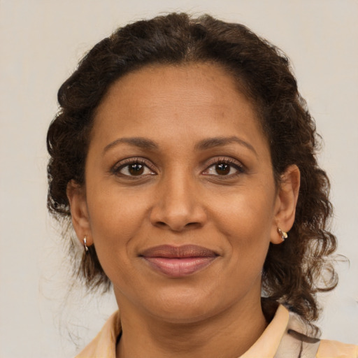 Joyful latino adult female with medium  brown hair and brown eyes