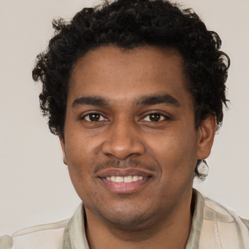 Joyful black young-adult male with short  brown hair and brown eyes