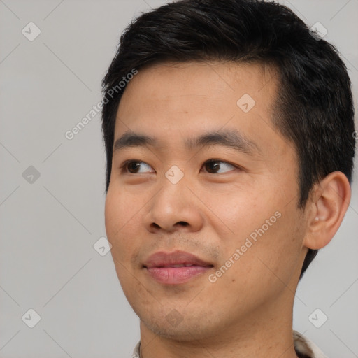 Joyful asian young-adult male with short  black hair and brown eyes