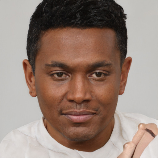 Joyful black young-adult male with short  brown hair and brown eyes
