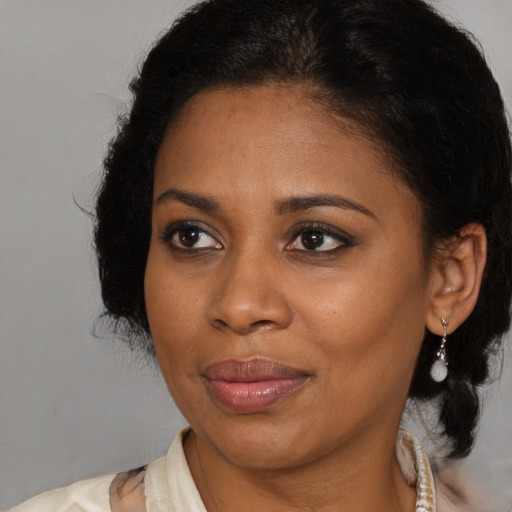 Joyful black young-adult female with medium  brown hair and brown eyes