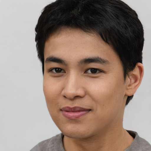 Joyful asian young-adult male with short  black hair and brown eyes