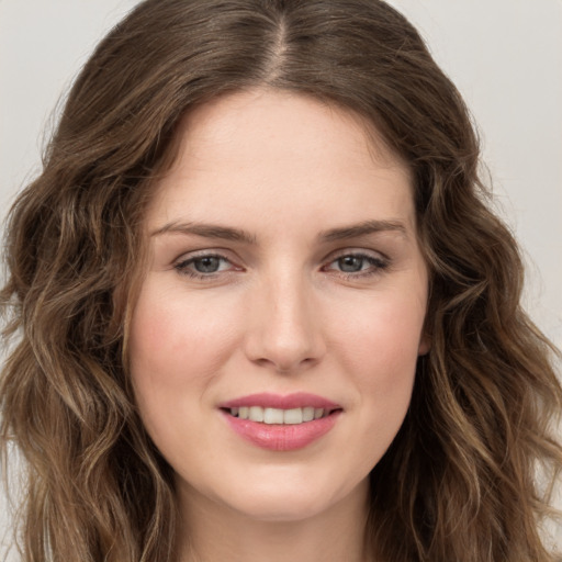 Joyful white young-adult female with long  brown hair and green eyes