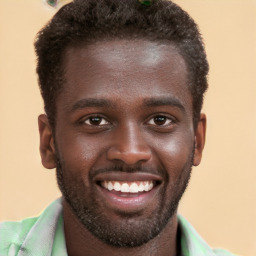 Joyful black young-adult male with short  brown hair and brown eyes