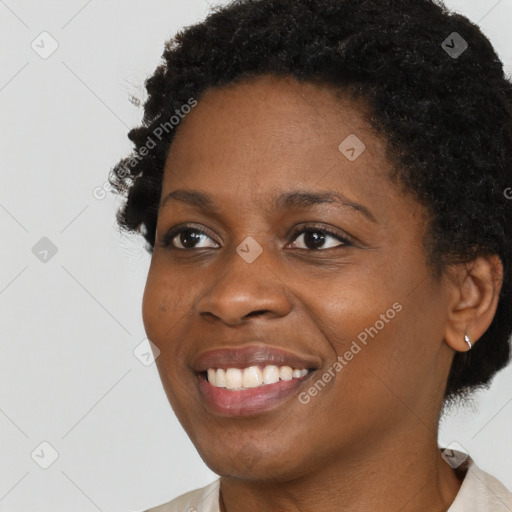 Joyful black young-adult female with short  black hair and brown eyes