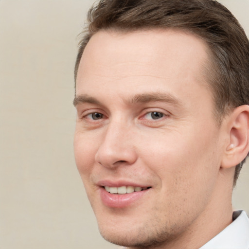 Joyful white young-adult male with short  brown hair and grey eyes