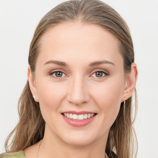 Joyful white young-adult female with long  brown hair and grey eyes