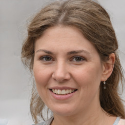 Joyful white adult female with medium  brown hair and grey eyes