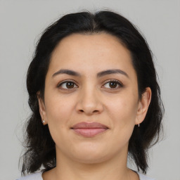 Joyful latino young-adult female with medium  brown hair and brown eyes