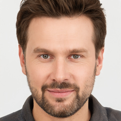 Joyful white young-adult male with short  brown hair and grey eyes