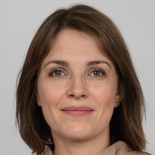 Joyful white adult female with medium  brown hair and grey eyes