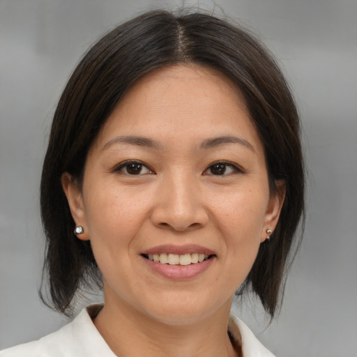 Joyful asian adult female with medium  brown hair and brown eyes