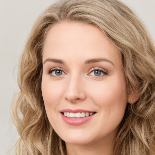 Joyful white young-adult female with long  brown hair and blue eyes