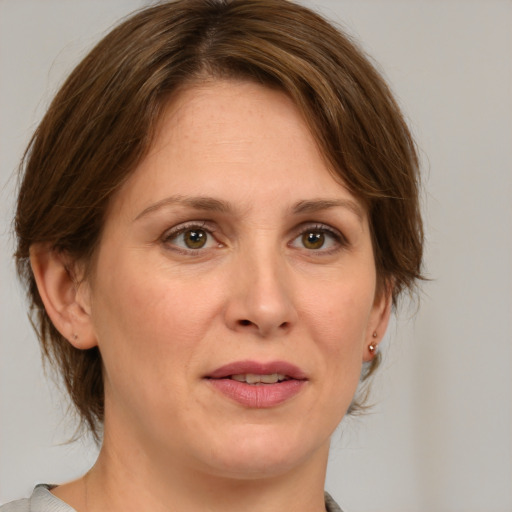 Joyful white adult female with medium  brown hair and green eyes