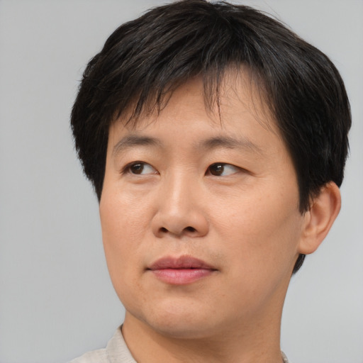 Joyful asian adult male with short  brown hair and brown eyes