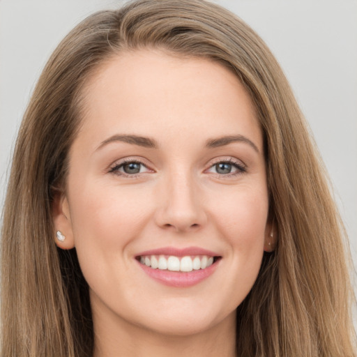 Joyful white young-adult female with long  brown hair and grey eyes