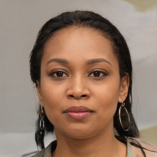 Joyful black young-adult female with long  black hair and brown eyes