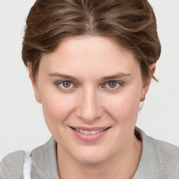 Joyful white young-adult female with short  brown hair and blue eyes