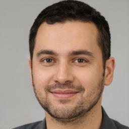 Joyful white young-adult male with short  brown hair and brown eyes