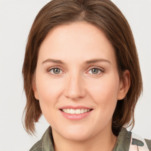 Joyful white young-adult female with medium  brown hair and green eyes